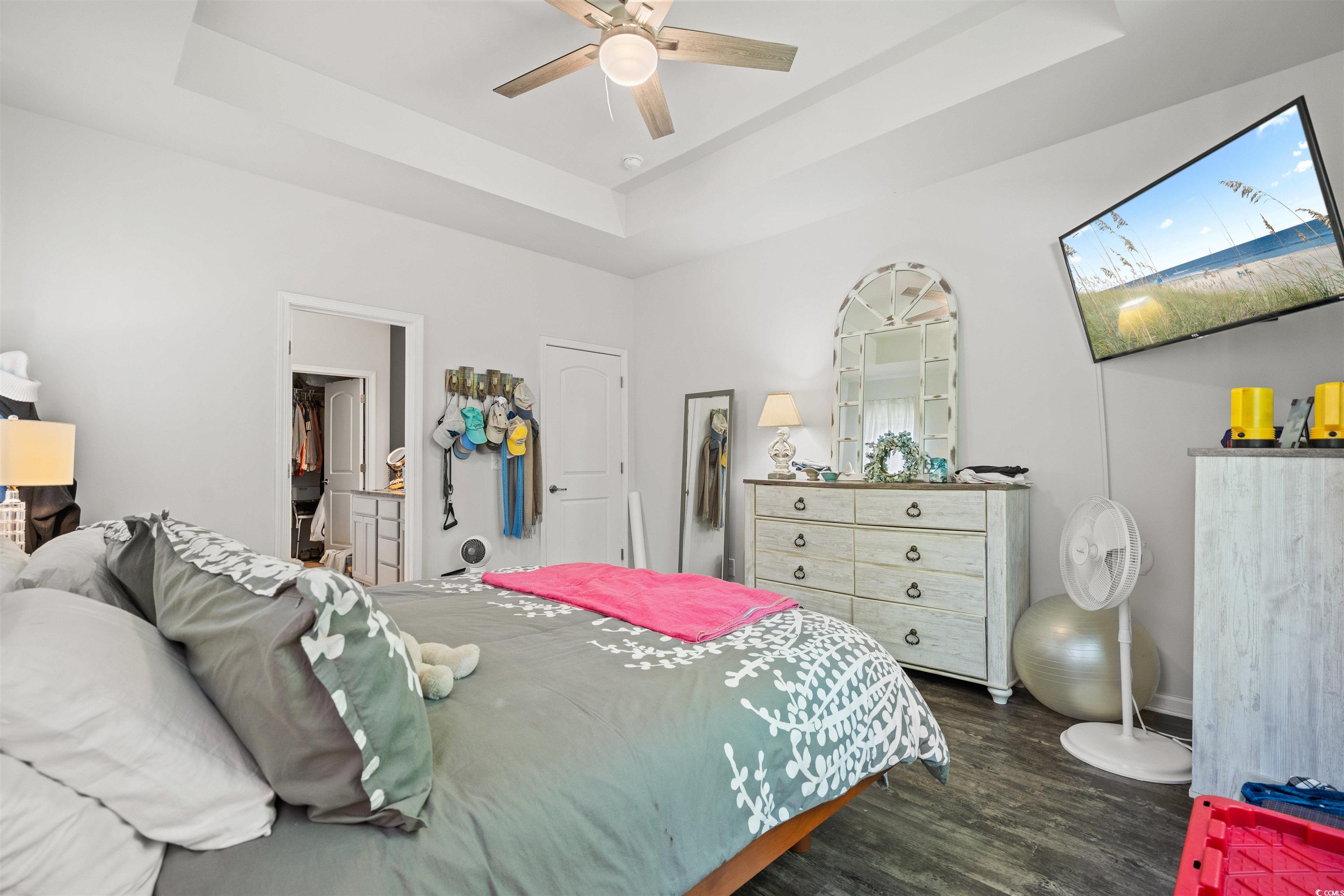 826 Cypress Way Little River, SC 29566 - Photo 22 of 40 Bedroom with a raised ceiling, dark wood-style flooring, and a ceiling fan