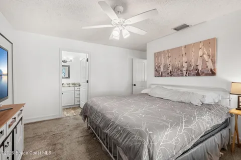a spacious bedroom with a bed and a painting on the wall