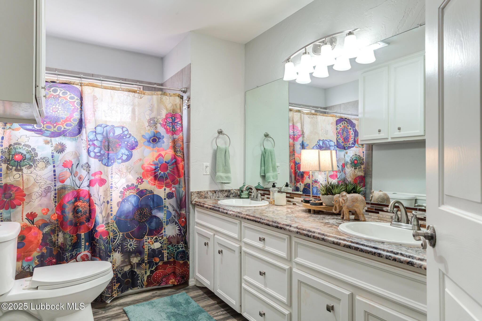 144 North Utica Avenue Lubbock, TX 79416 - Photo 35 of 46 a bathroom with a sink vanity mirror and a toilet