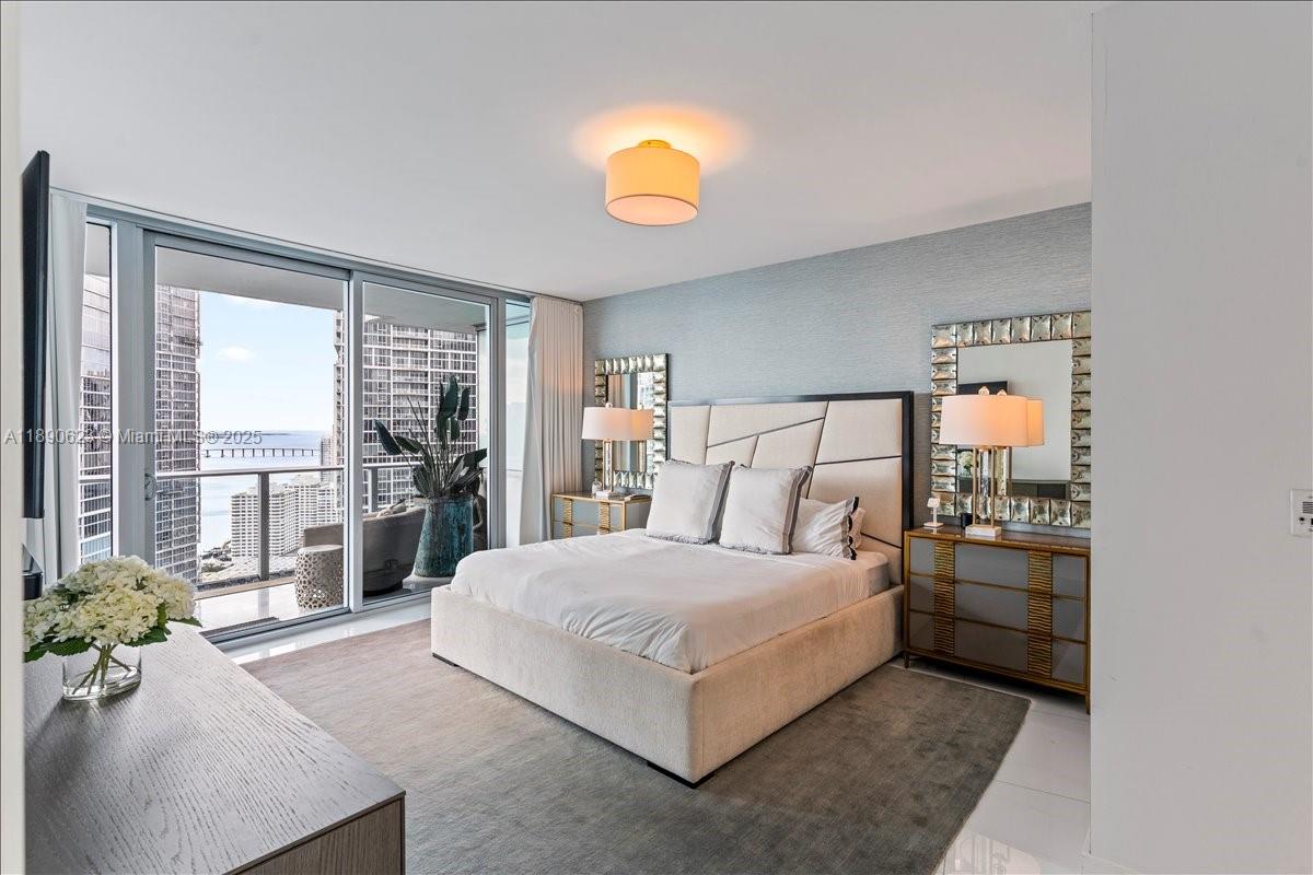 200 Biscayne Blvd Way, Unit 3608 Miami, FL 33131 - Photo 12 of 31 a bedroom with a bed and a lamp on table