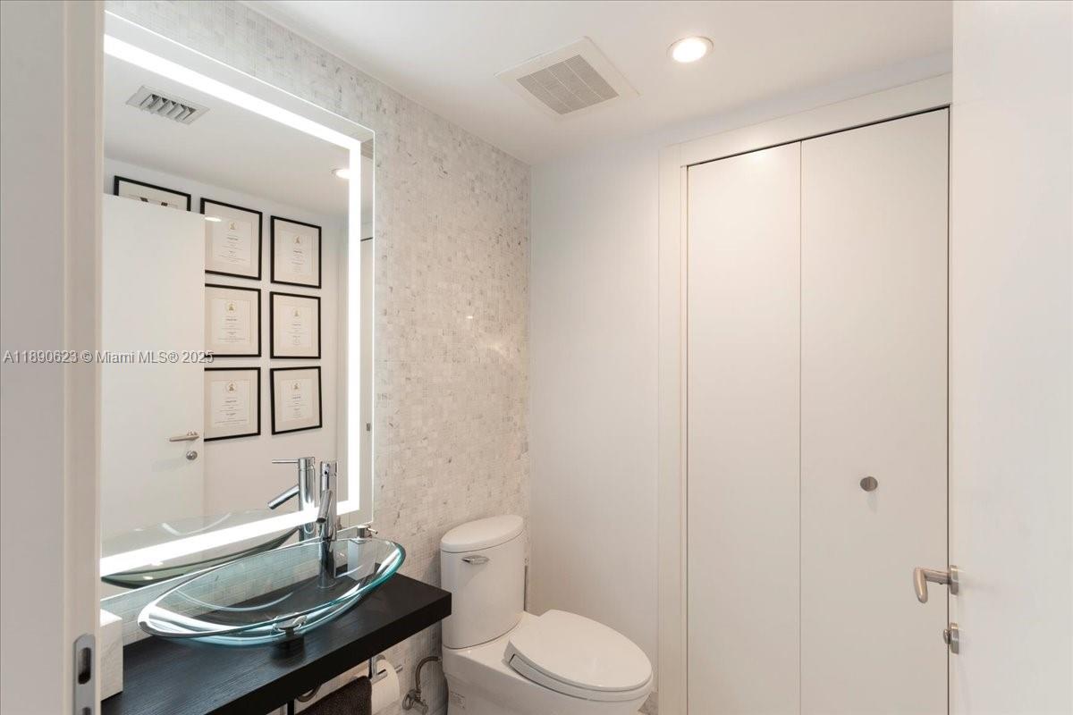 200 Biscayne Blvd Way, Unit 3608 Miami, FL 33131 - Photo 22 of 31 a bathroom with a granite countertop sink toilet and shower