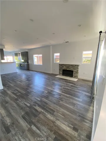 a view of a livingroom with wooden floor and a fireplace