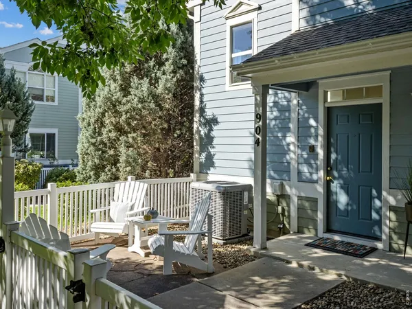 a view of a patio with table and chairs and wooden fence