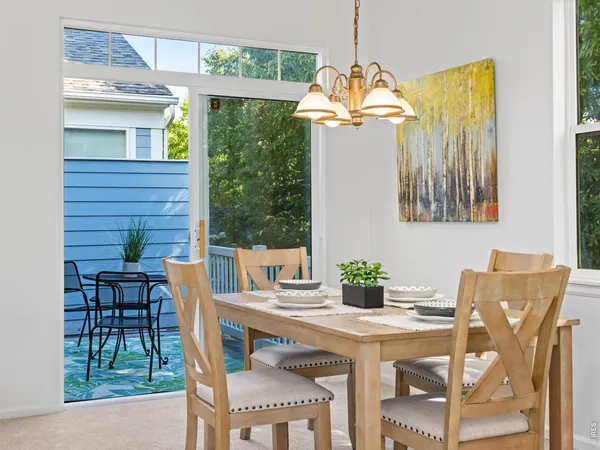 a dining room with furniture a chandelier and wooden floor