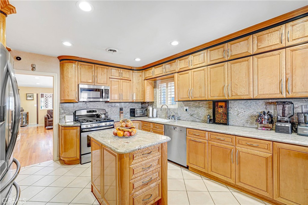 4313 Rhodes Avenue Studio City, CA 91604 - Photo 5 of 23 a kitchen with stainless steel appliances granite countertop a stove top oven a sink a refrigerator and white cabinets