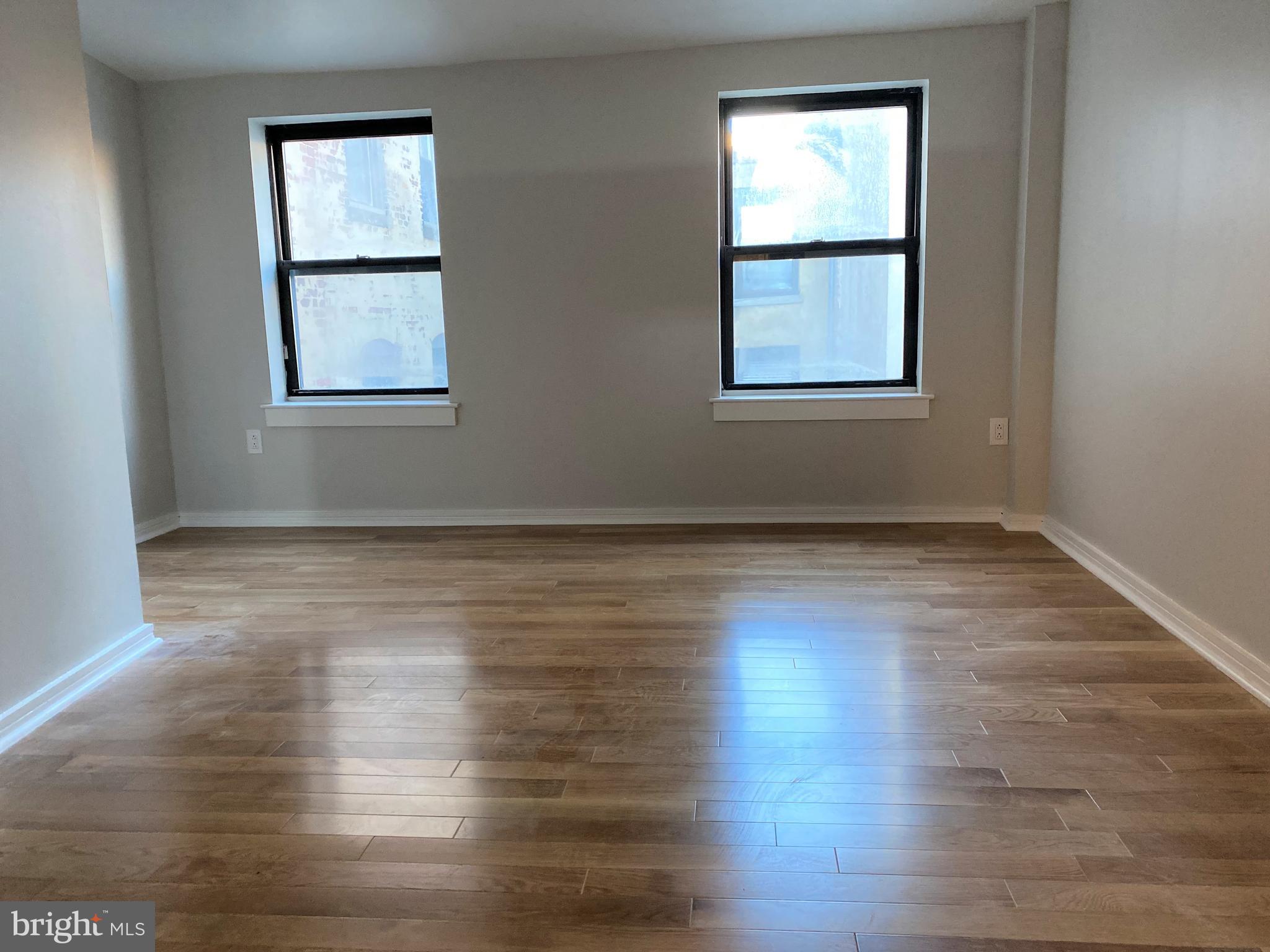 222 Church Street, Unit 4K Philadelphia, PA 19106 - Photo 11 of 16 a view of an empty room with wooden floor and a window