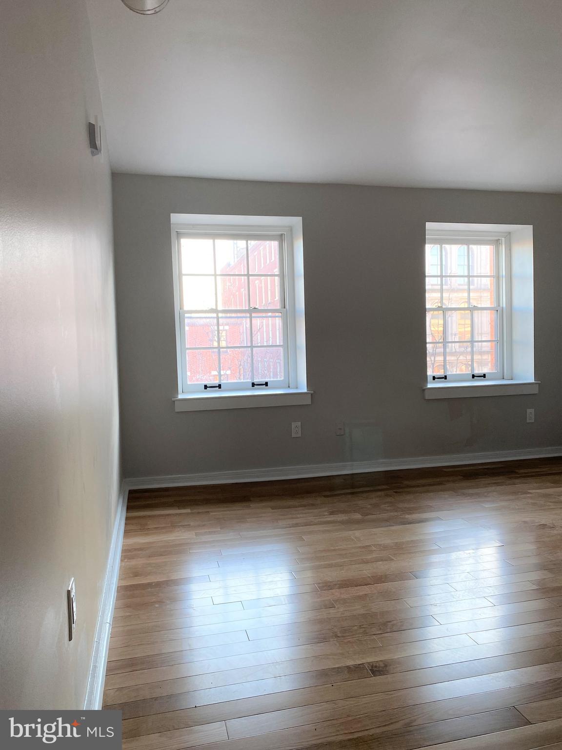 222 Church Street, Unit 4K Philadelphia, PA 19106 - Photo 13 of 16 an empty room with wooden floor and windows