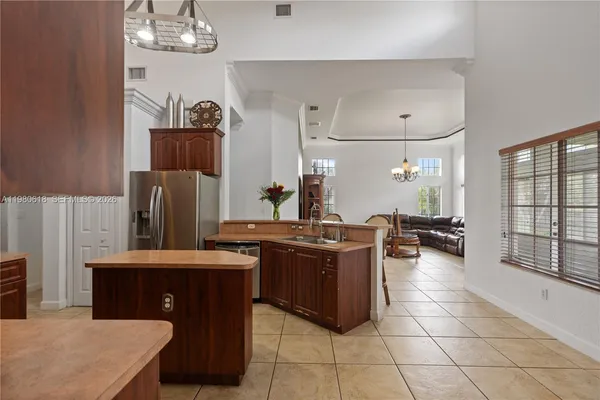 a kitchen with stainless steel appliances granite countertop a stove a refrigerator a oven a sink with a dining table and chairs