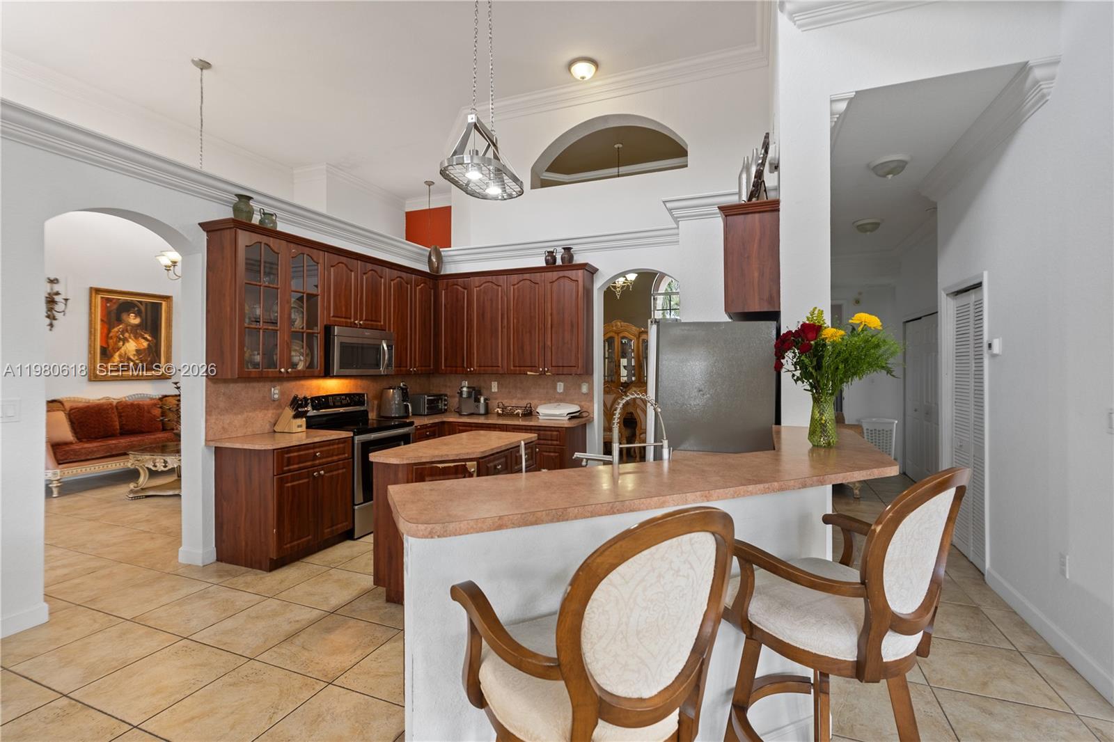 12981 Southwest 197th Street Miami, FL 33177 - Photo 20 of 75 a kitchen with stainless steel appliances granite countertop a stove a refrigerator a oven a sink with a dining table and chairs