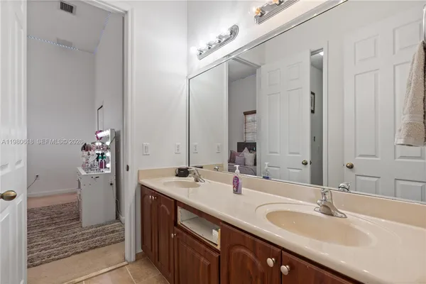 a bathroom with a granite countertop sink a mirror and a shower