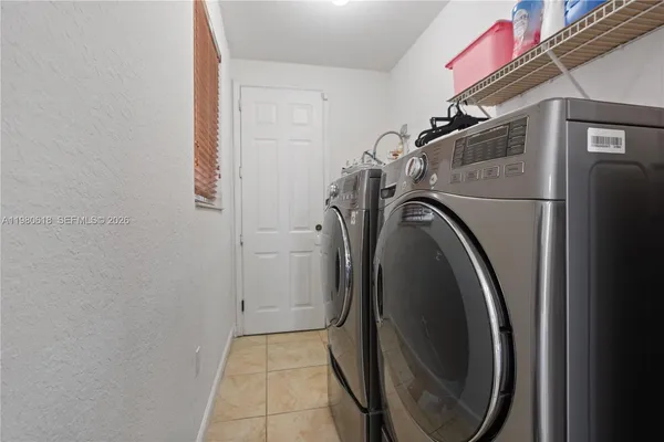 a bedroom with a bed and a refrigerator