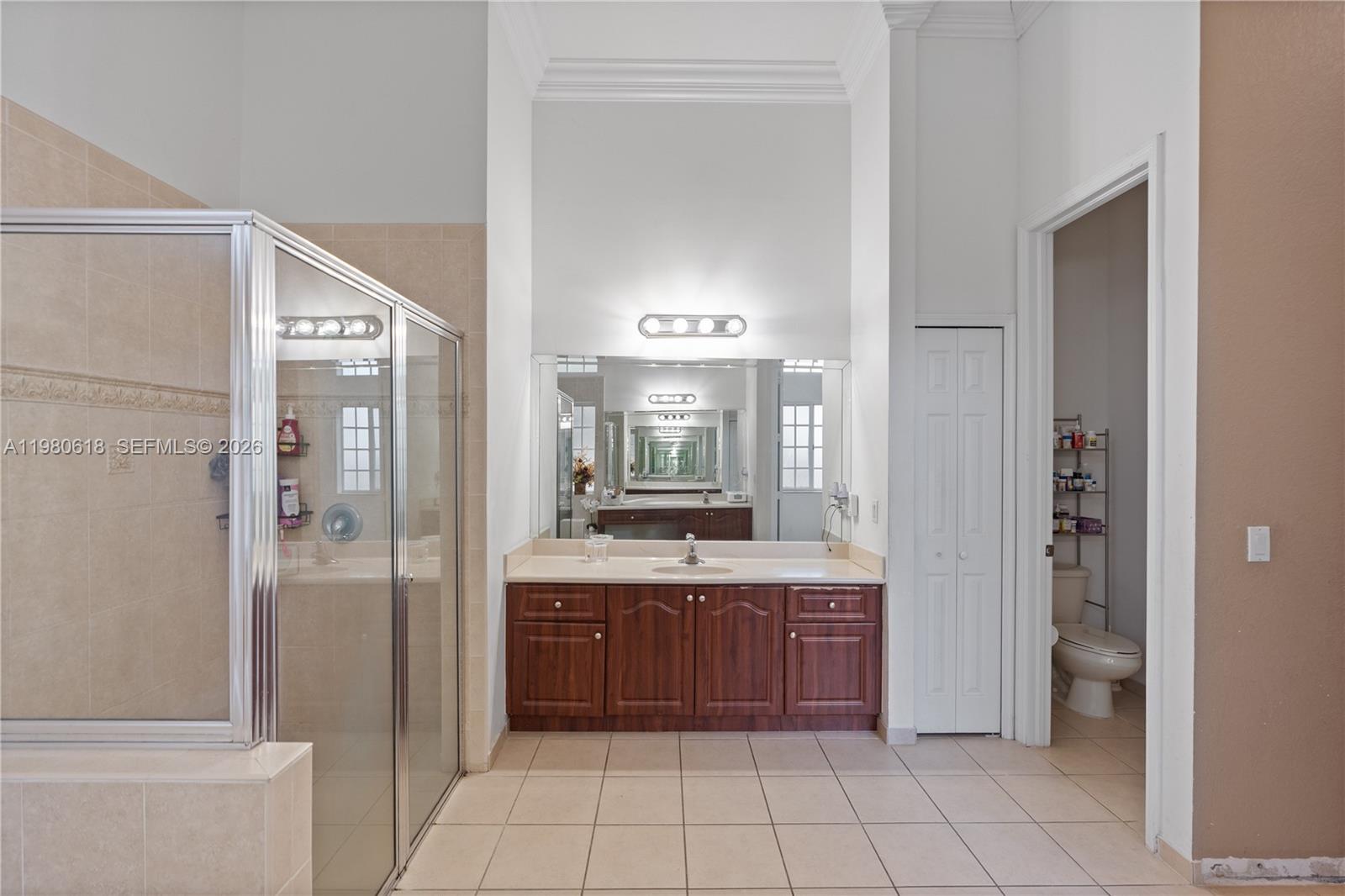 12981 Southwest 197th Street Miami, FL 33177 - Photo 43 of 75 a bathroom with a granite countertop sink a mirror and a shower