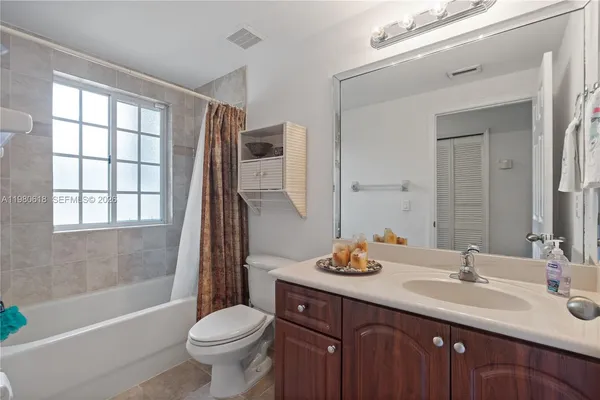 a front view of a house with a yard and palm trees