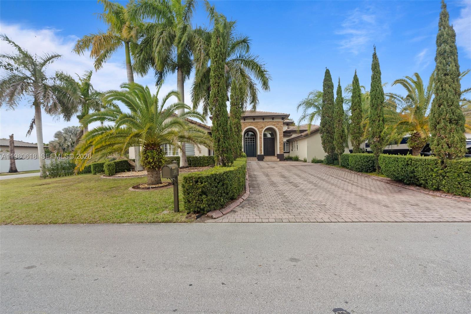 12981 Southwest 197th Street Miami, FL 33177 - Photo 65 of 75 a front view of a house with a yard and palm trees