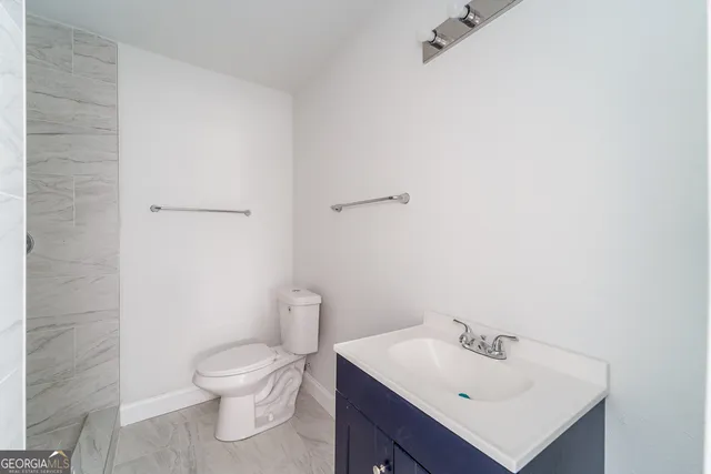 a bathroom with a sink mirror and toilet