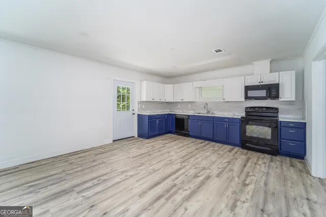 a kitchen with stainless steel appliances kitchen island wooden cabinets and entryway