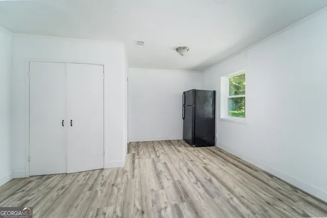 a view of an empty room with closet and a window