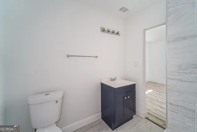 a bathroom with a toilet a sink and mirror