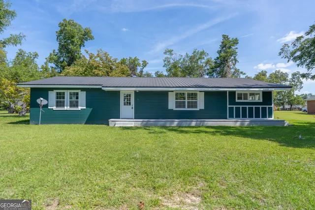 a view of a house with a backyard