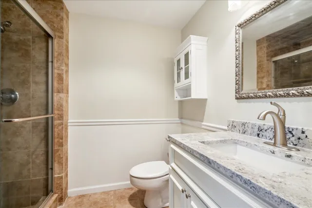 a bathroom with a granite countertop sink toilet and shower