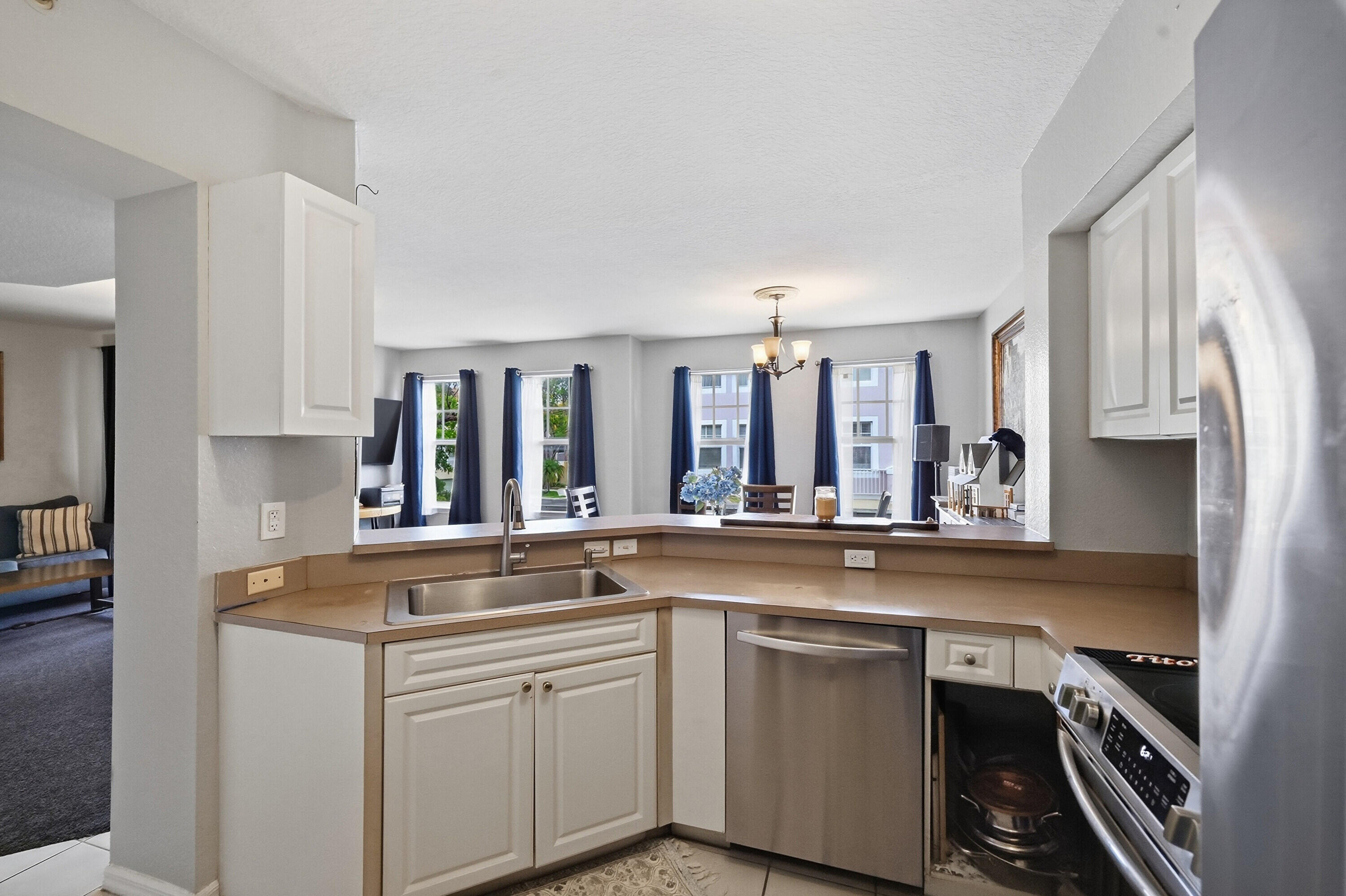 6450 West Sample Road, Unit 6450 Coral Springs, FL 33067 - Photo 11 of 41 a kitchen with stainless steel appliances a sink stove and cabinets