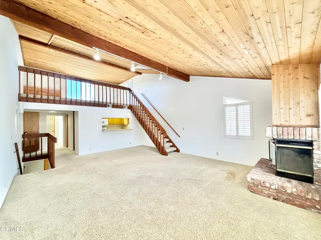 a view of an empty room with fireplace and a window