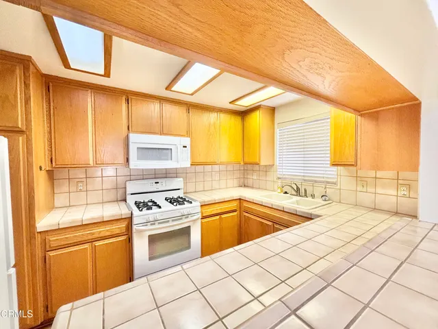 a kitchen with a sink a stove and cabinets