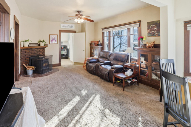380 North 200 West Logan, UT 84321 - Photo 4 of 29 Living room featuring light carpet, ceiling fan, and a wood stove