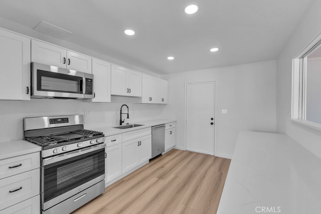 a kitchen with sink a microwave and cabinets