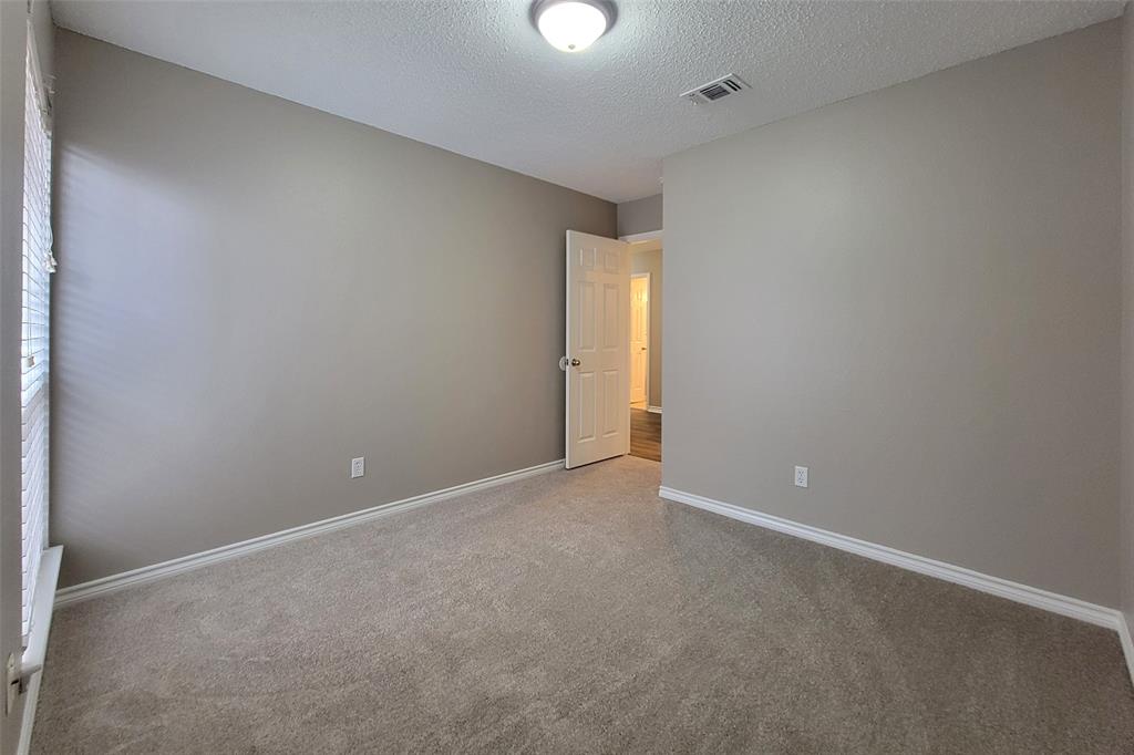 1604 Knoll Ridge Circle Corinth, TX 76210 - Photo 29 of 37 Carpeted room featuring a neutral color palette, white trim, a flush mount ceiling light, and a window with blinds