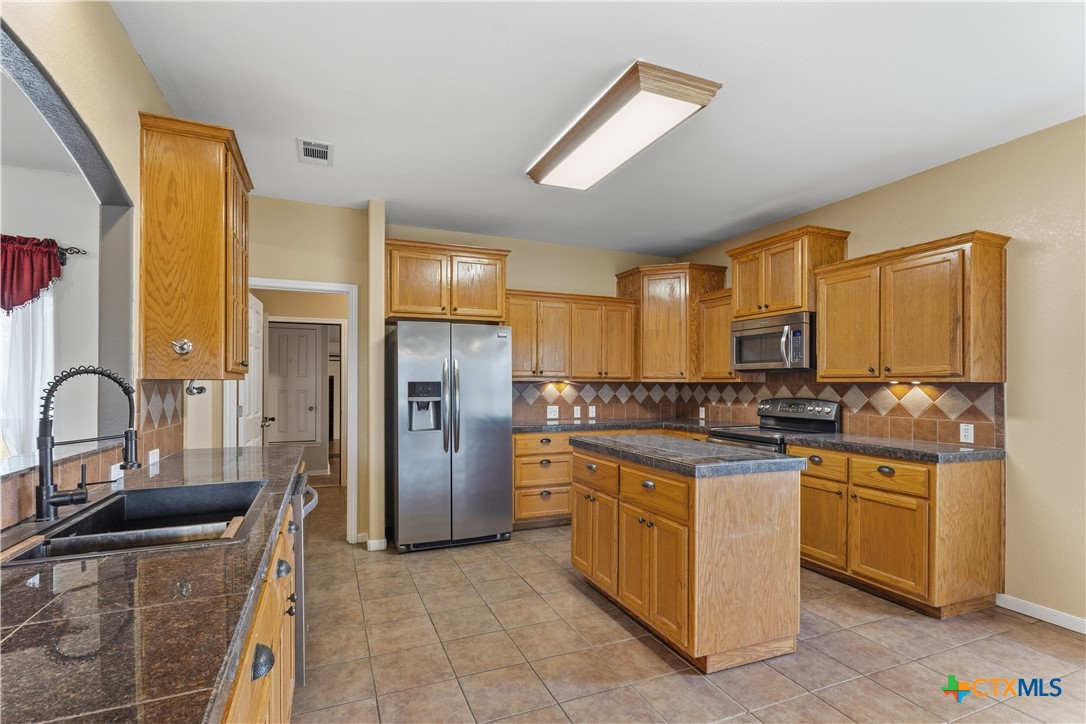 283 County Road 4710 Kempner, TX 76539 - Photo 19 of 47 a kitchen with stainless steel appliances granite countertop a stove a sink a refrigerator and cabinets
