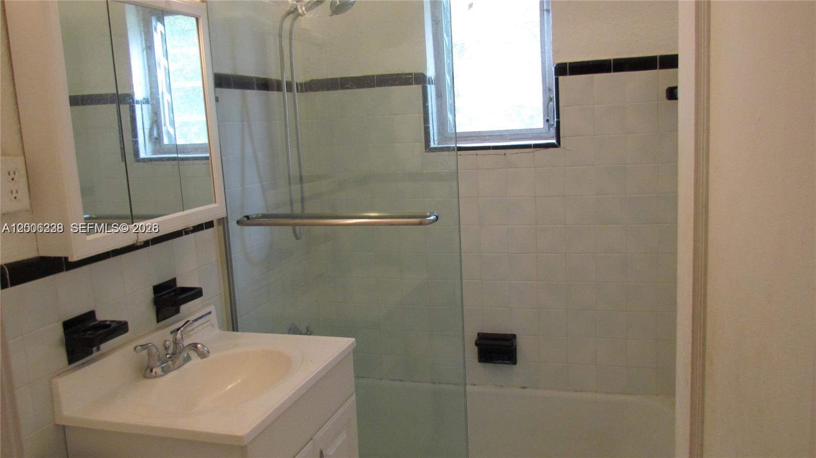 7920 Harding Avenue, Unit 10 Miami Beach, FL 33141 - Photo 5 of 6 a bathroom with a sink a window and shower