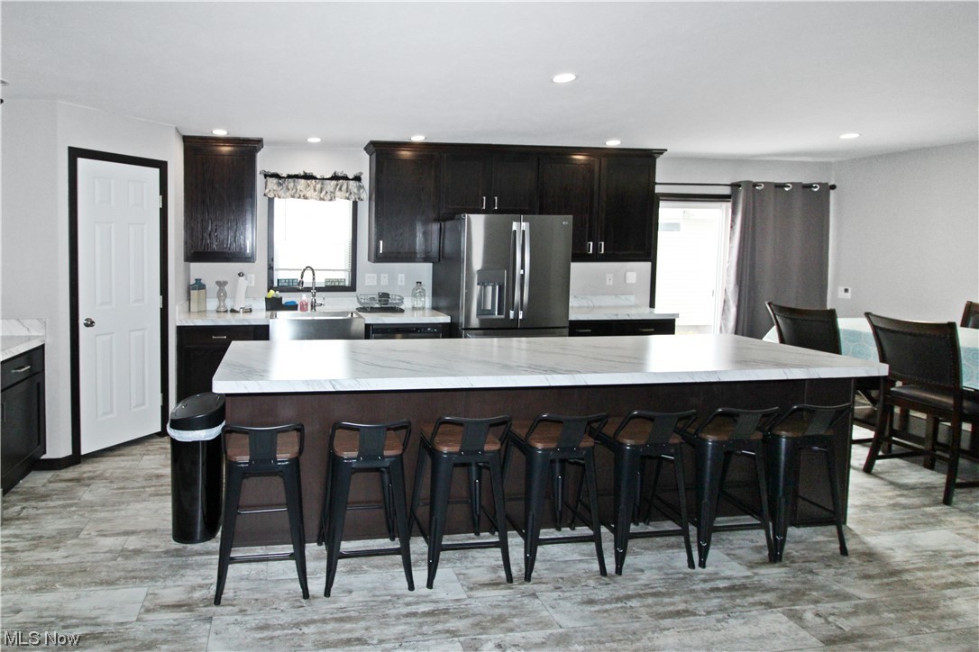 1609 Coldwater Crossing Road Lakeside Marblehead, OH 43440 - Photo 31 of 38 Kitchen with a kitchen island, plenty of natural light, stainless steel fridge, and a breakfast bar
