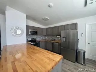 a kitchen with granite countertop a refrigerator stove and sink