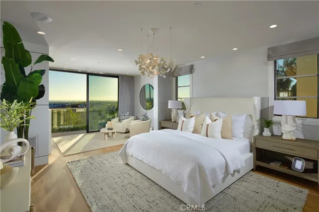 a spacious bedroom with a large bed and a chandelier