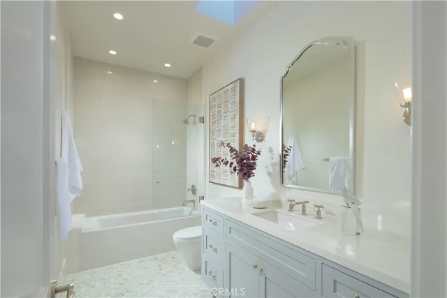 a bathroom with a granite countertop sink a toilet and shower