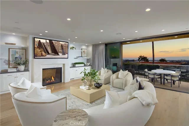 a living room with furniture a fireplace and a floor to ceiling window