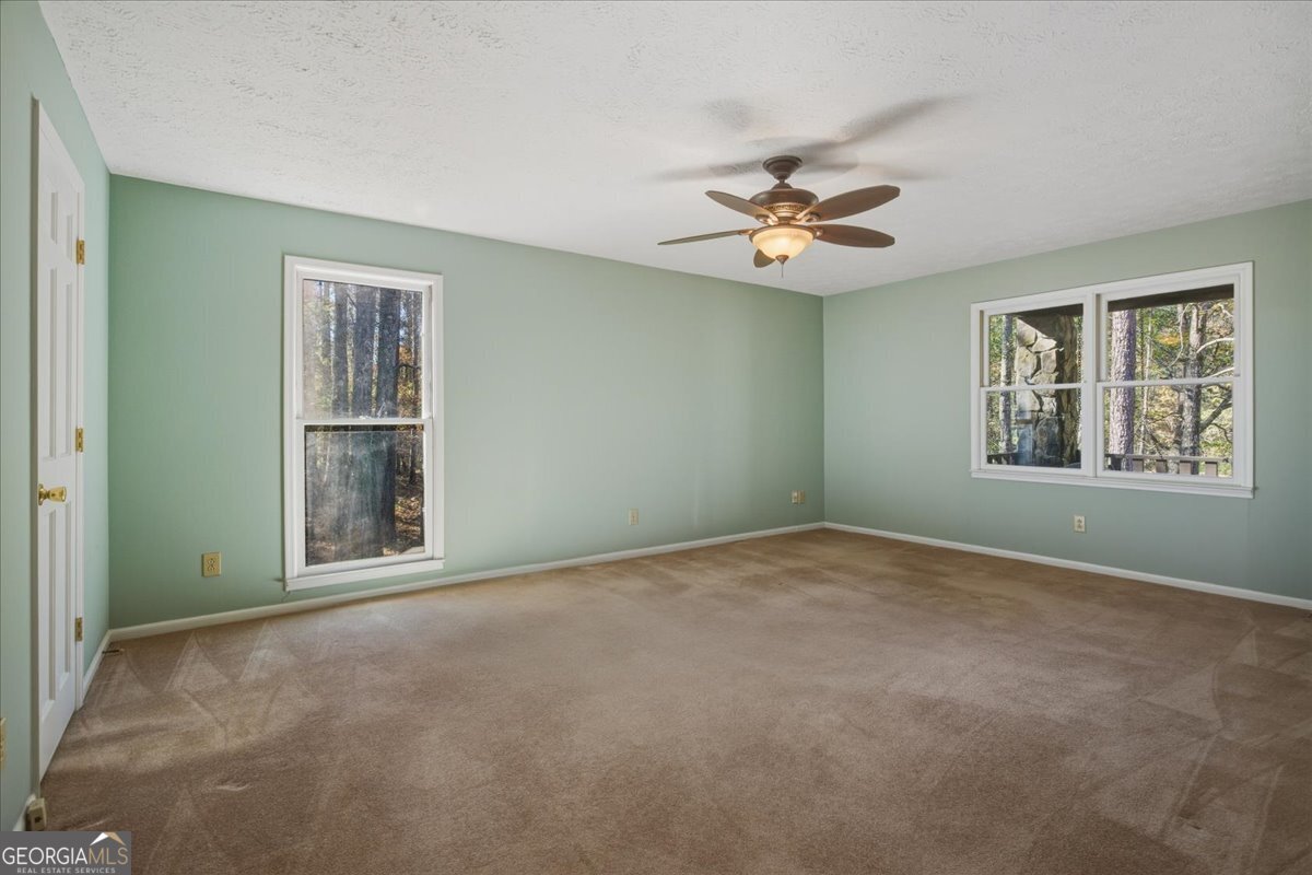 590 South New Salem Road Griffin, GA 30223 - Photo 20 of 52 an empty room with windows and fan chandelier fan