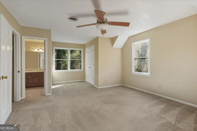 an empty room with windows and fan