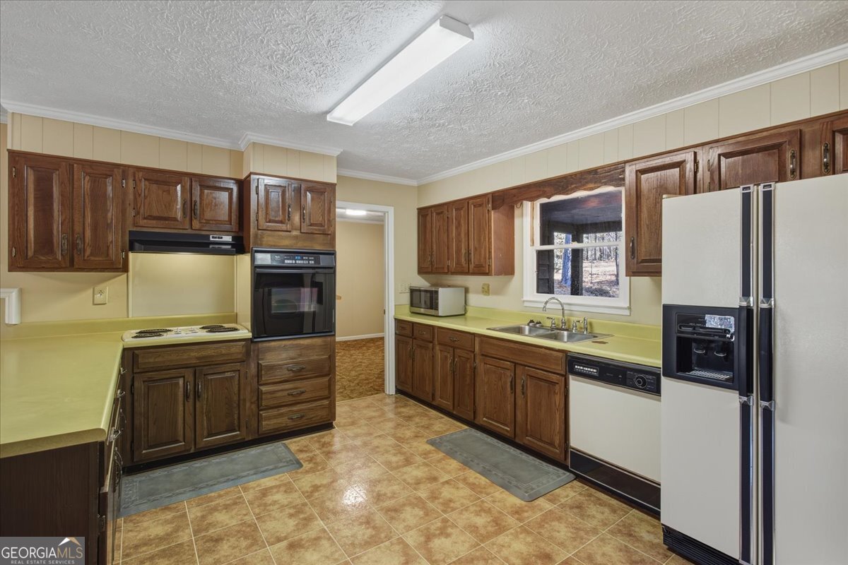 590 South New Salem Road Griffin, GA 30223 - Photo 8 of 52 a kitchen with granite countertop a refrigerator stove top oven and sink