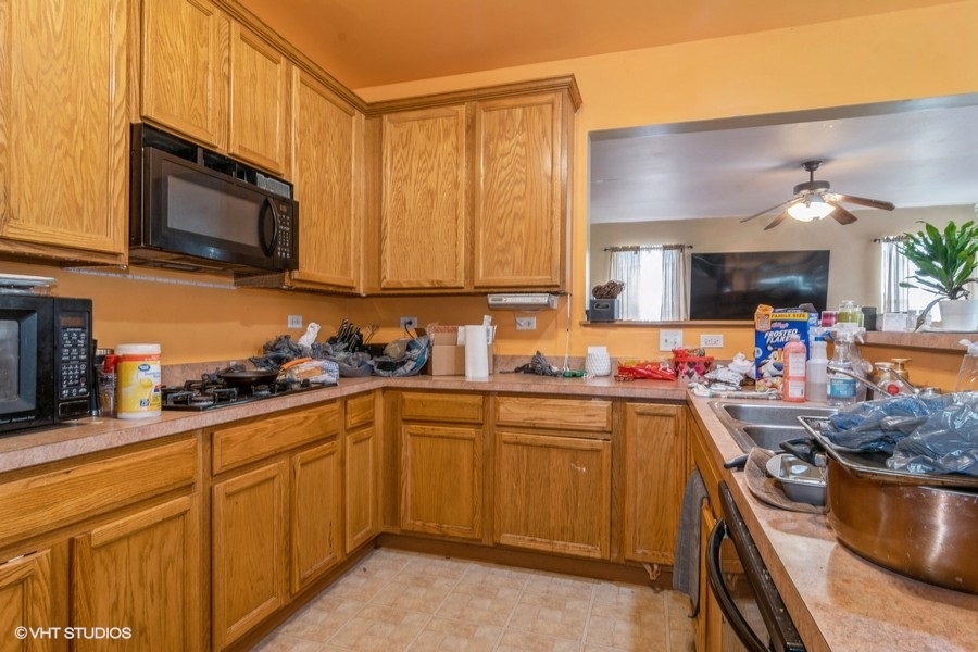 384 Kensington Drive Oswego, IL 60543 - Photo 5 of 15 a kitchen with stainless steel appliances granite countertop a sink stove and microwave