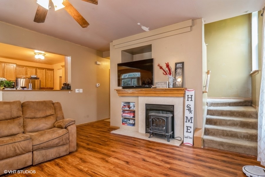 384 Kensington Drive Oswego, IL 60543 - Photo 6 of 15 a living room with furniture and a fireplace