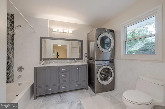a bathroom with a granite countertop toilet and a sink