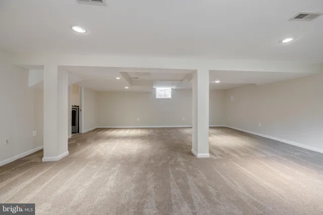 a view of a big room with wooden floor and windows
