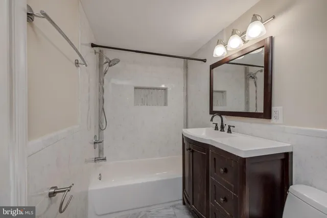 a bathroom with a tub sink and mirror