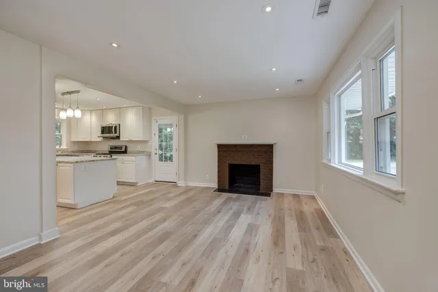 a view of kitchen with granite countertop cabinets stainless steel appliances and a fireplace