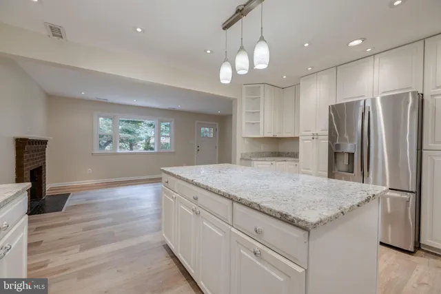 a kitchen with stainless steel appliances granite countertop a sink and a refrigerator