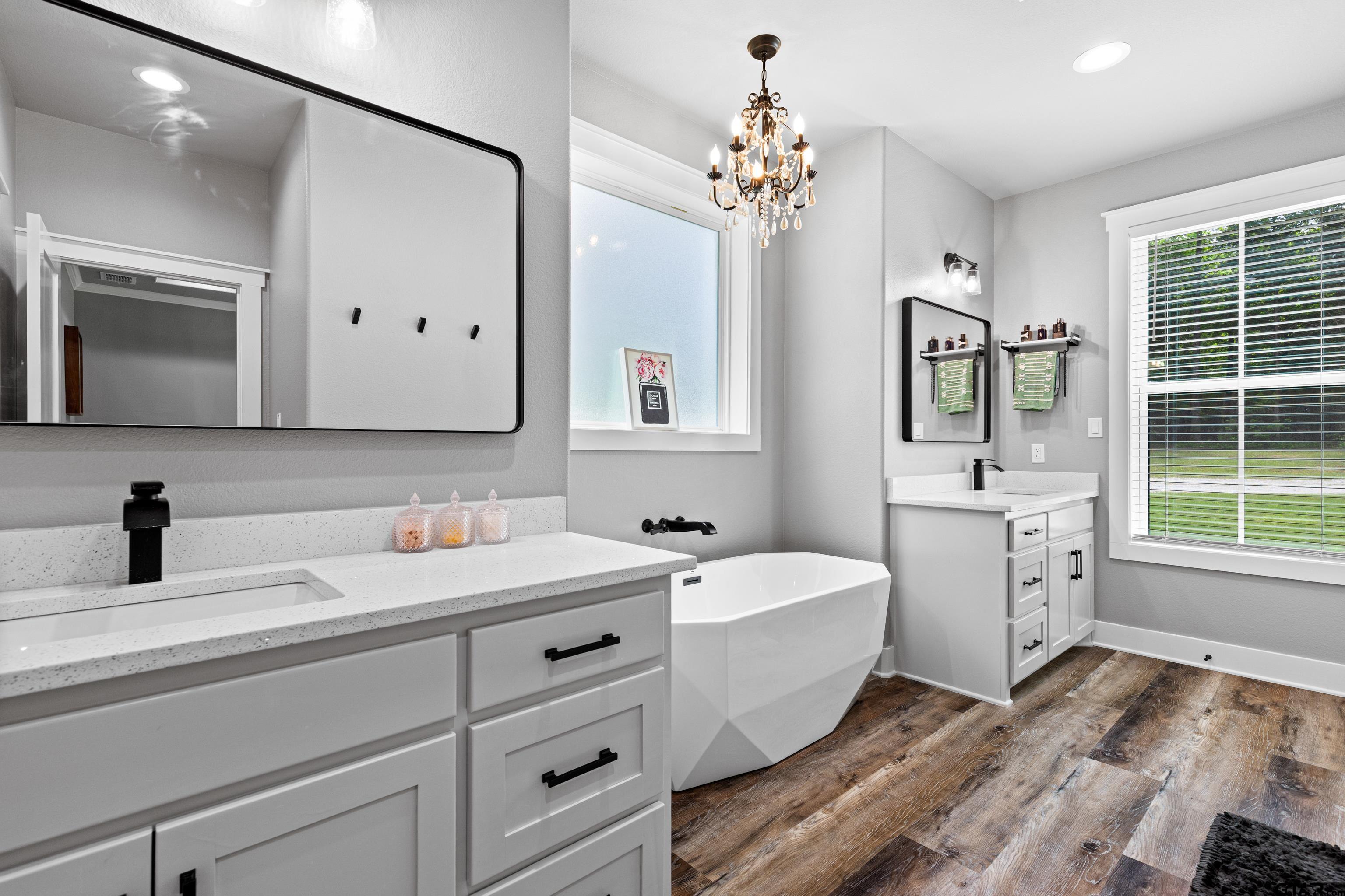 2505 Airstrip Road Gilmer, TX 75644 - Photo 20 of 37 a bathroom with a double vanity sink a mirror a bathtub and window