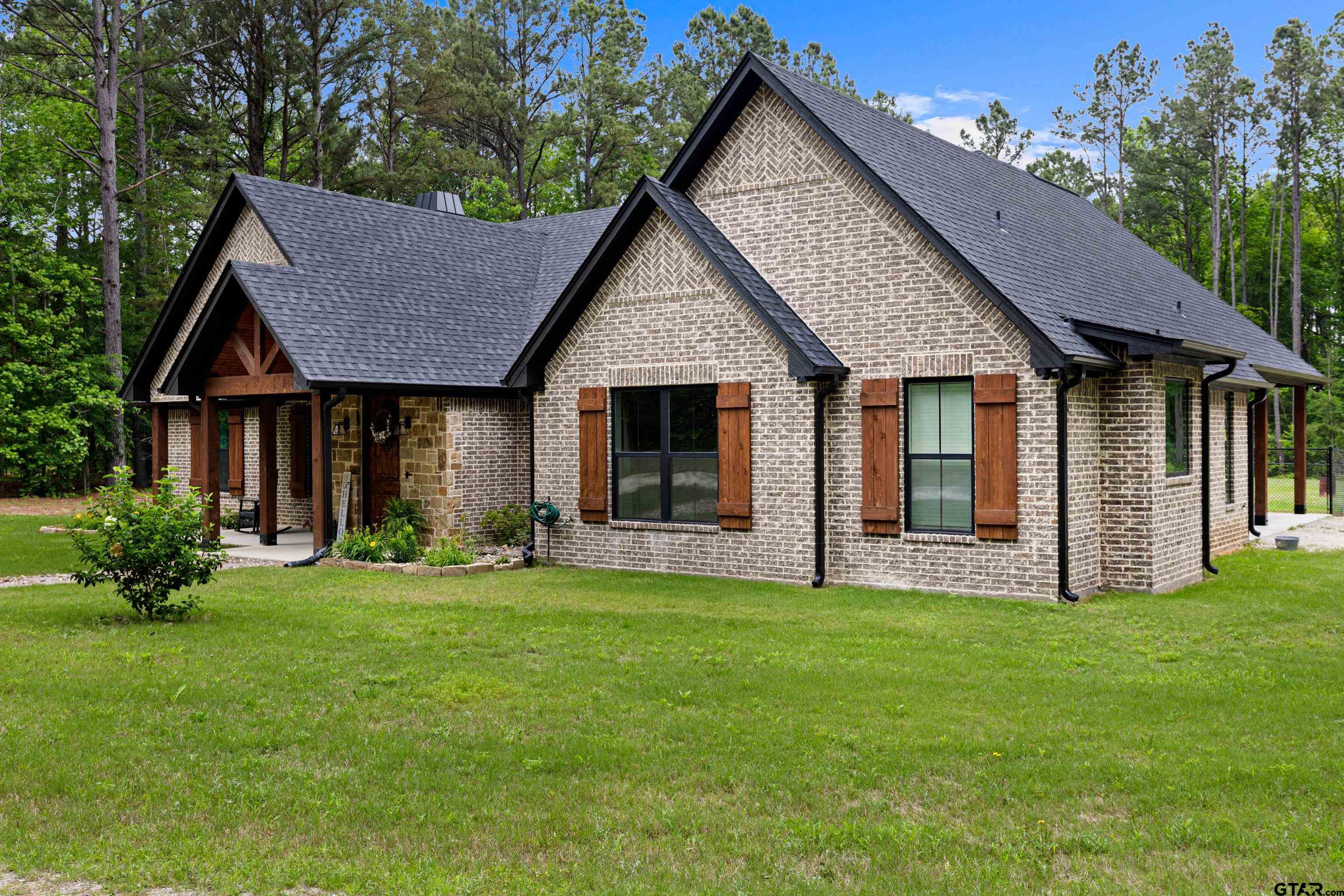 2505 Airstrip Road Gilmer, TX 75644 - Photo 34 of 37 a front view of a house with a garden and yard