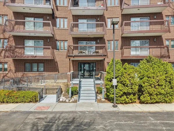 a front view of a residential apartment building with a yard